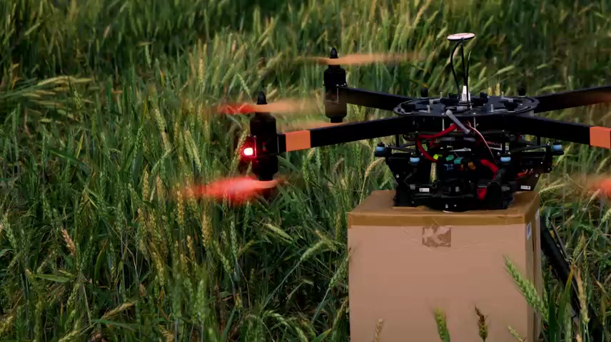 无人机带着包裹在一块空地上起飞.