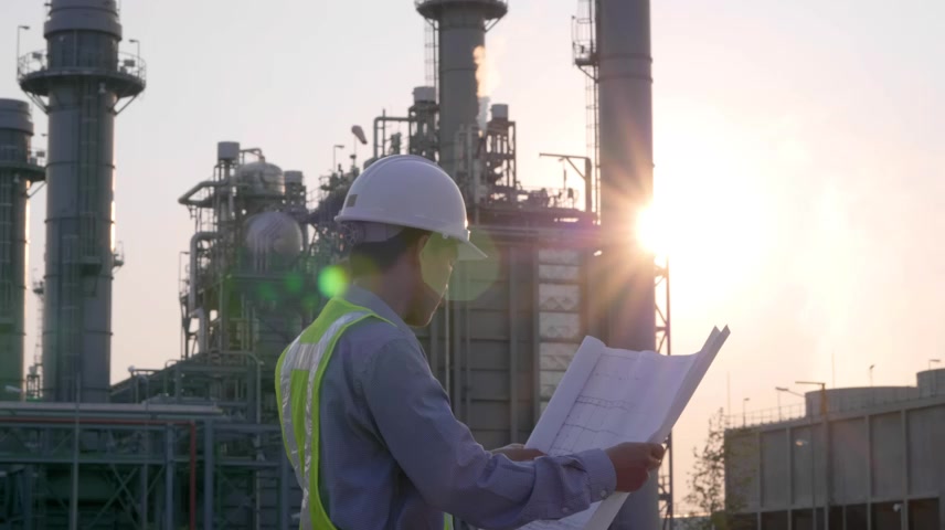 男工程师正在研究发电厂工人安全控制的蓝图.