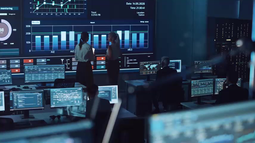 两名软件工程师在一个大屏幕旁聊天.