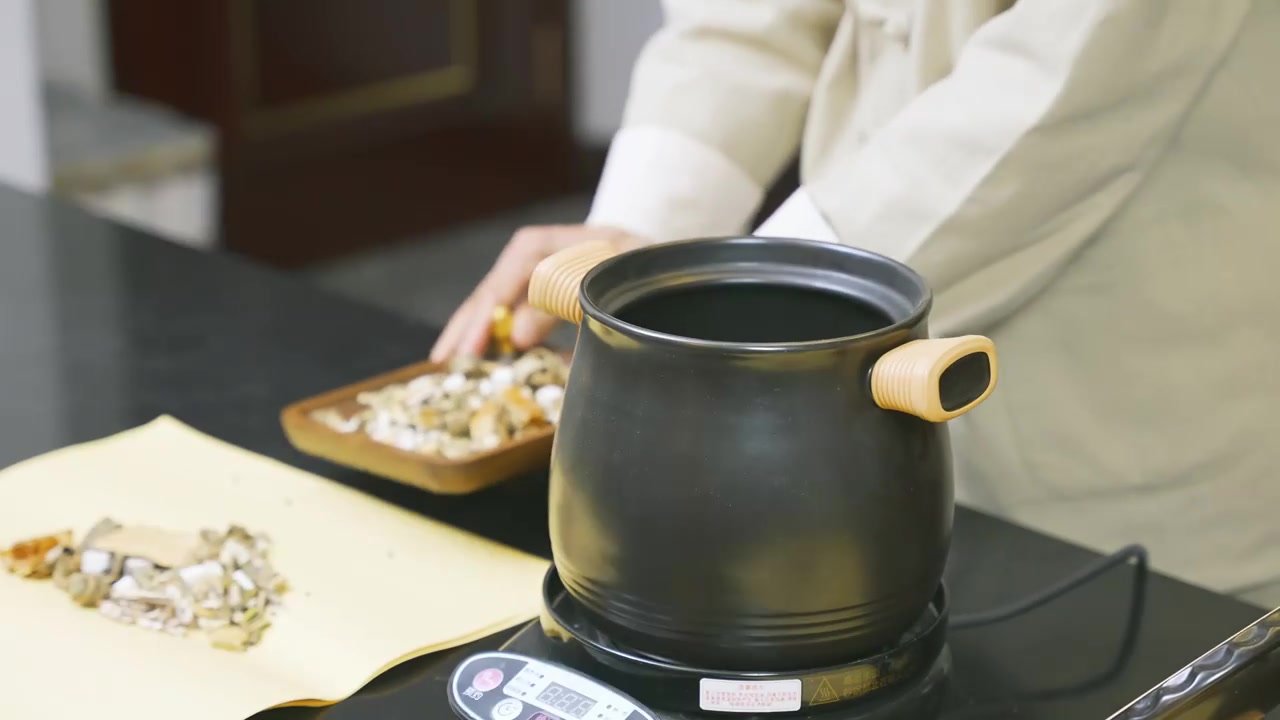 中医中草药材倒入煎药壶