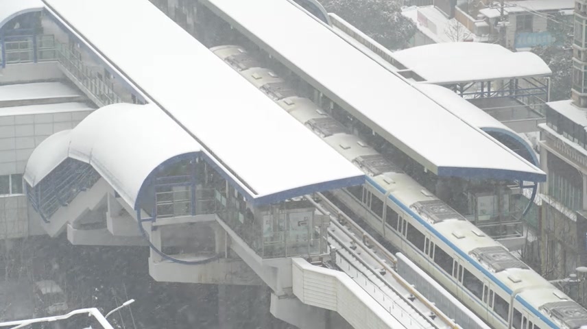 航拍冬天城市暴风雪里行驶的轨道交通列车