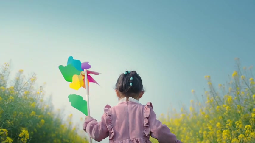 小孩在油菜花田玩风车小孩奔跑阳光明媚.