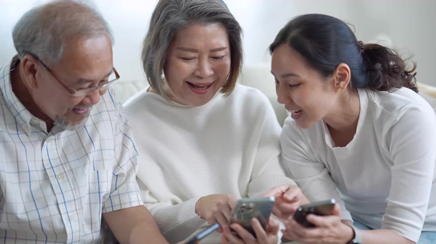 一家人坐在一起使用手机.