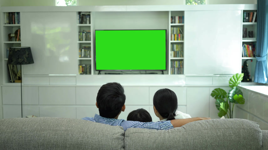 用绿色屏幕显示器观看电视的家庭.